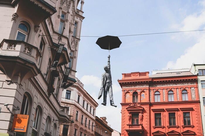 Umbrella Man Statue Prague – A captivating sculpture of a man holding an umbrella, suspended in mid-air in the streets of Prague, created by Czech artist Michal Trpák.